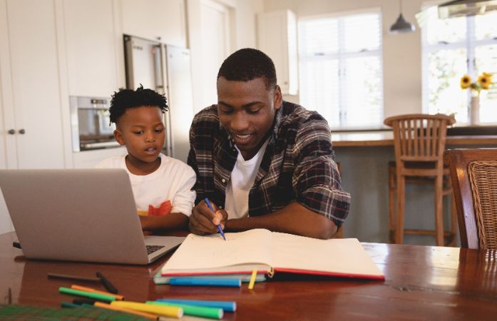  A parent helping a child with their virtual learning.